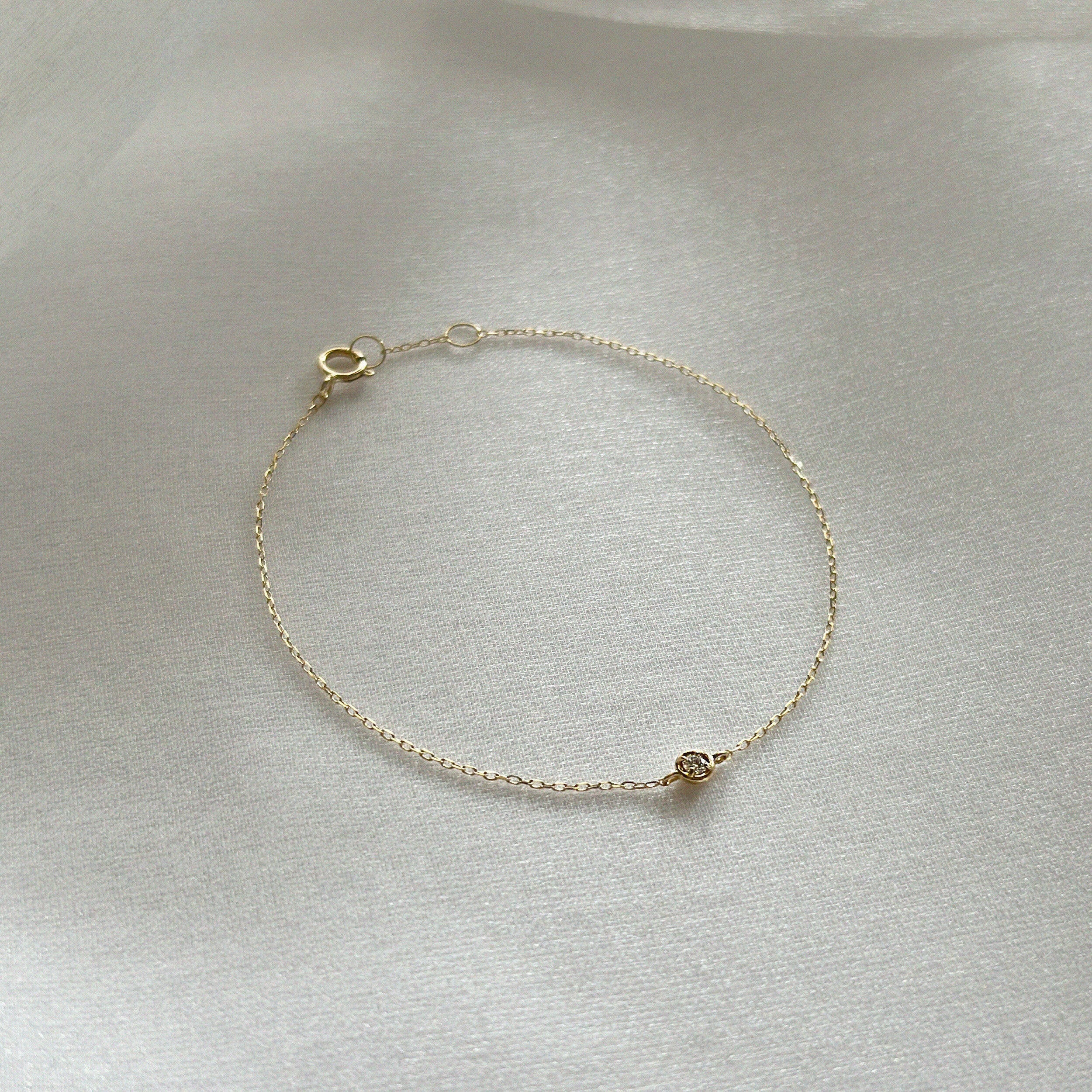 Dainty gold chain bracelet with brilliant diamond detail styled in soft light