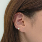 Dainty bow-shaped earring sparkling subtly in side profile