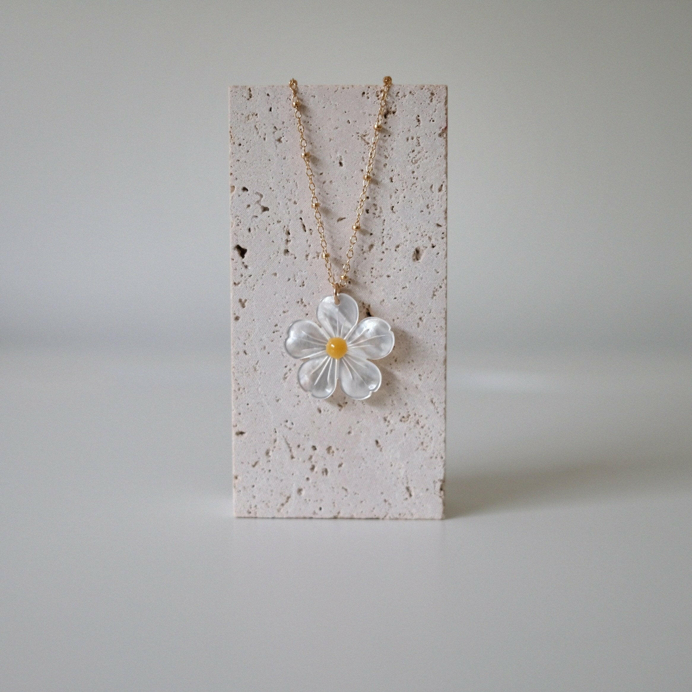 Necklace displayed on stone display with pendant centered