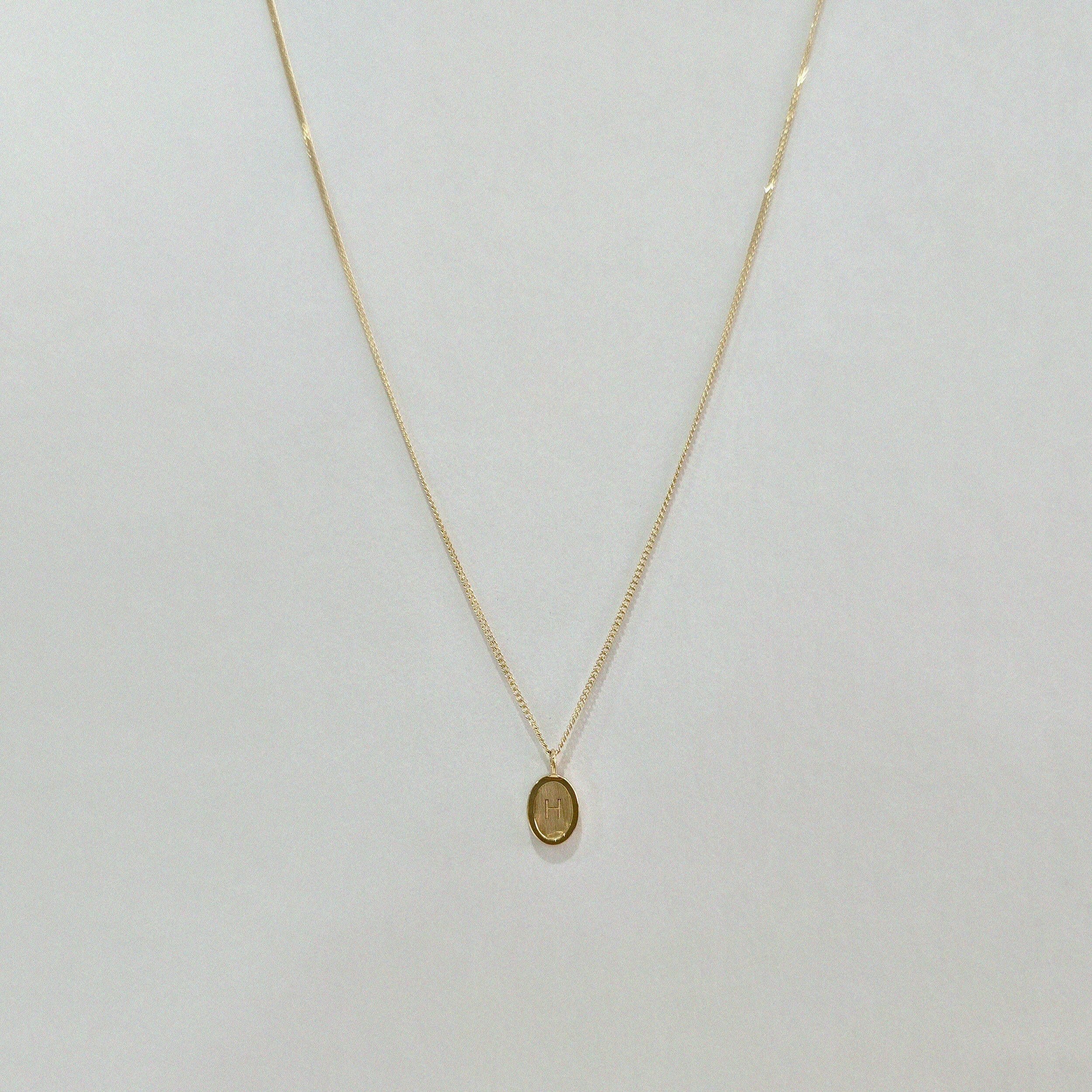 Front-facing image of Dear Initial Necklace showing full chain and oval pendant – minimalist and timeless in 14K gold