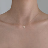 Model wearing Laondrim Dear Initial Necklace – delicate oval pendant in 14K gold