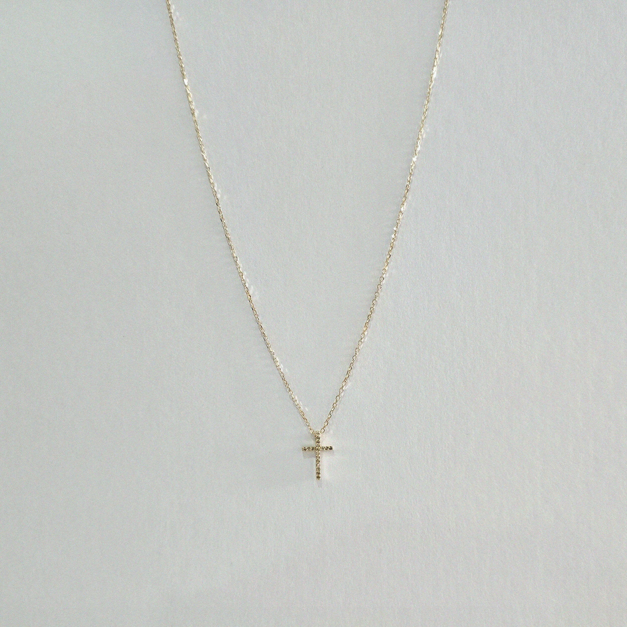 Symmetrical display of gold necklace showcasing detailed pendant and chain