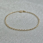 Delicate gold bracelet with oval link design styled in soft light