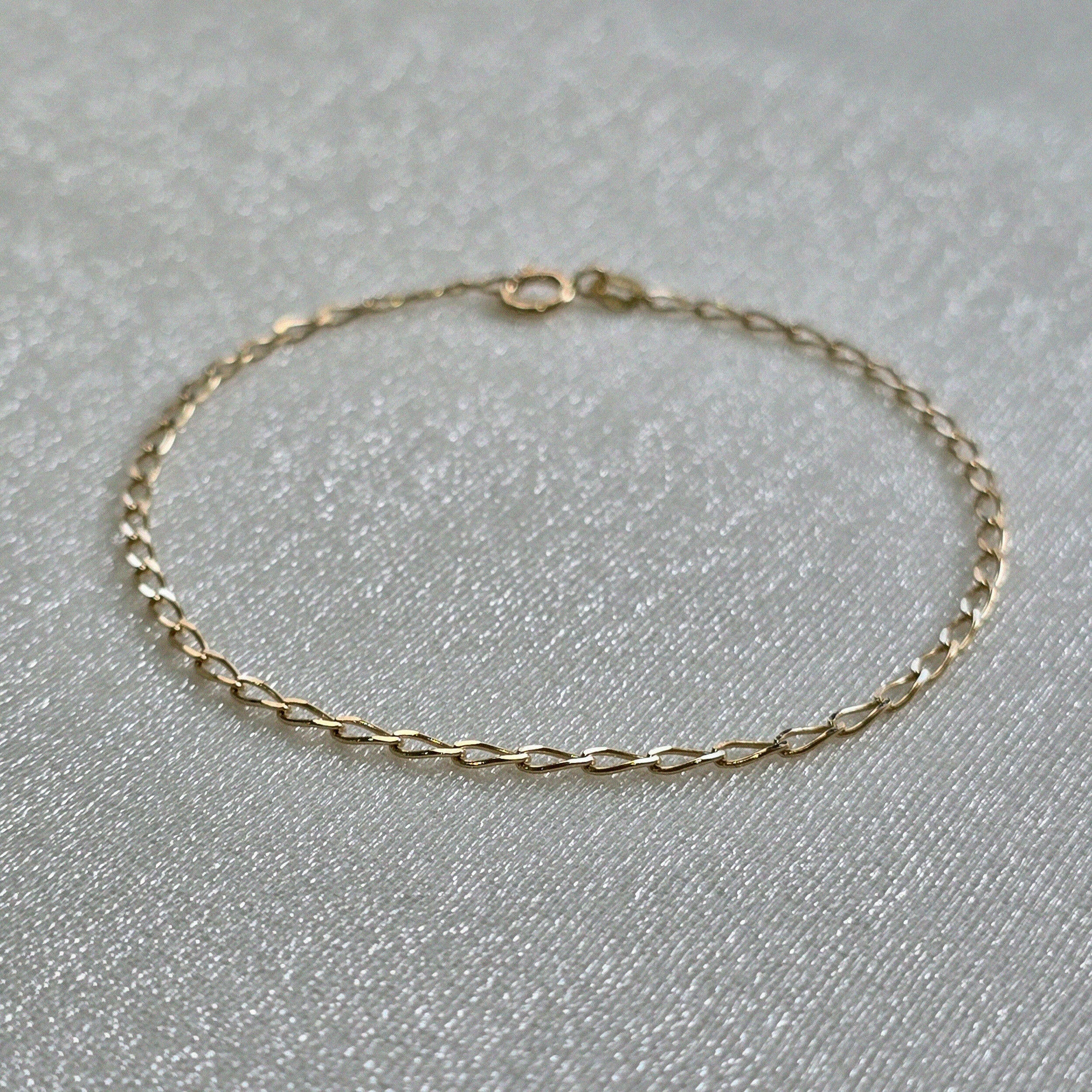 Delicate gold bracelet with oval link design styled in soft light