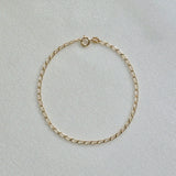 14K Elba Chain Bracelet with slim oval links displayed flat on textured background