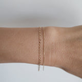 Model wearing the Elba Bracelet alongside fine gold chains for an elegant layered effect