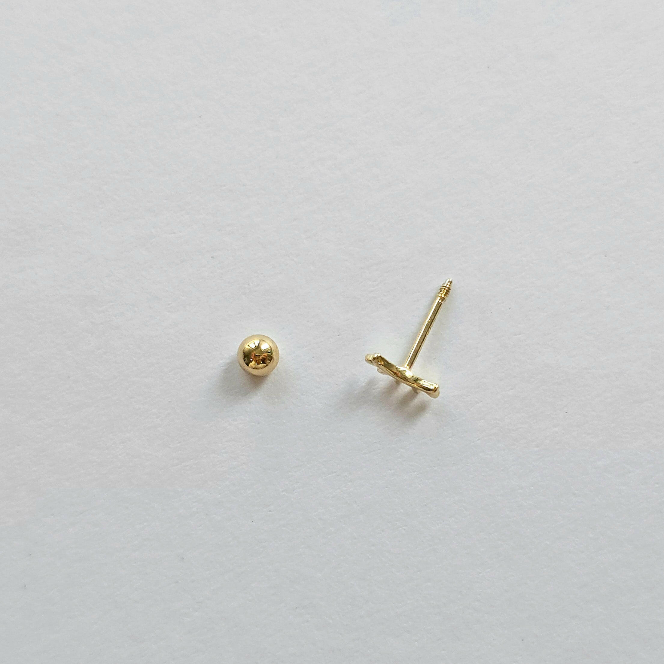 Aerial shot of screwball back and post detail on gold eyelash cartilage stud