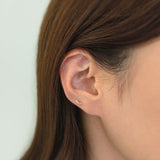Eyelash-shaped cartilage earring worn in low helix piercing with whimsical look