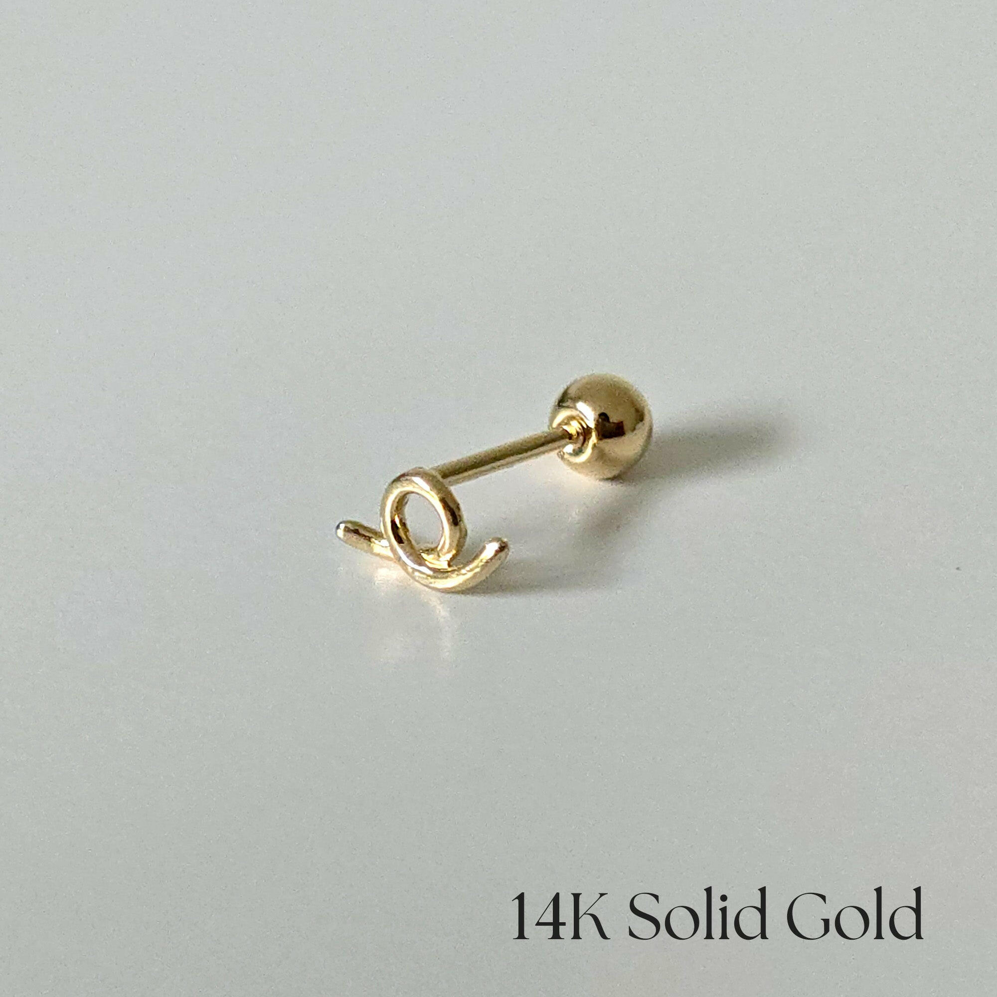 Side profile of 14K gold Freeline II cartilage earring with flowing abstract shape
