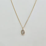 Close-up of 5x7mm marquise-cut cubic zirconia surrounded by micro-crystal halo in high-polish gold setting