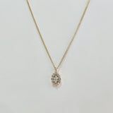 Close-up of 5x7mm marquise-cut cubic zirconia surrounded by micro-crystal halo in high-polish gold setting