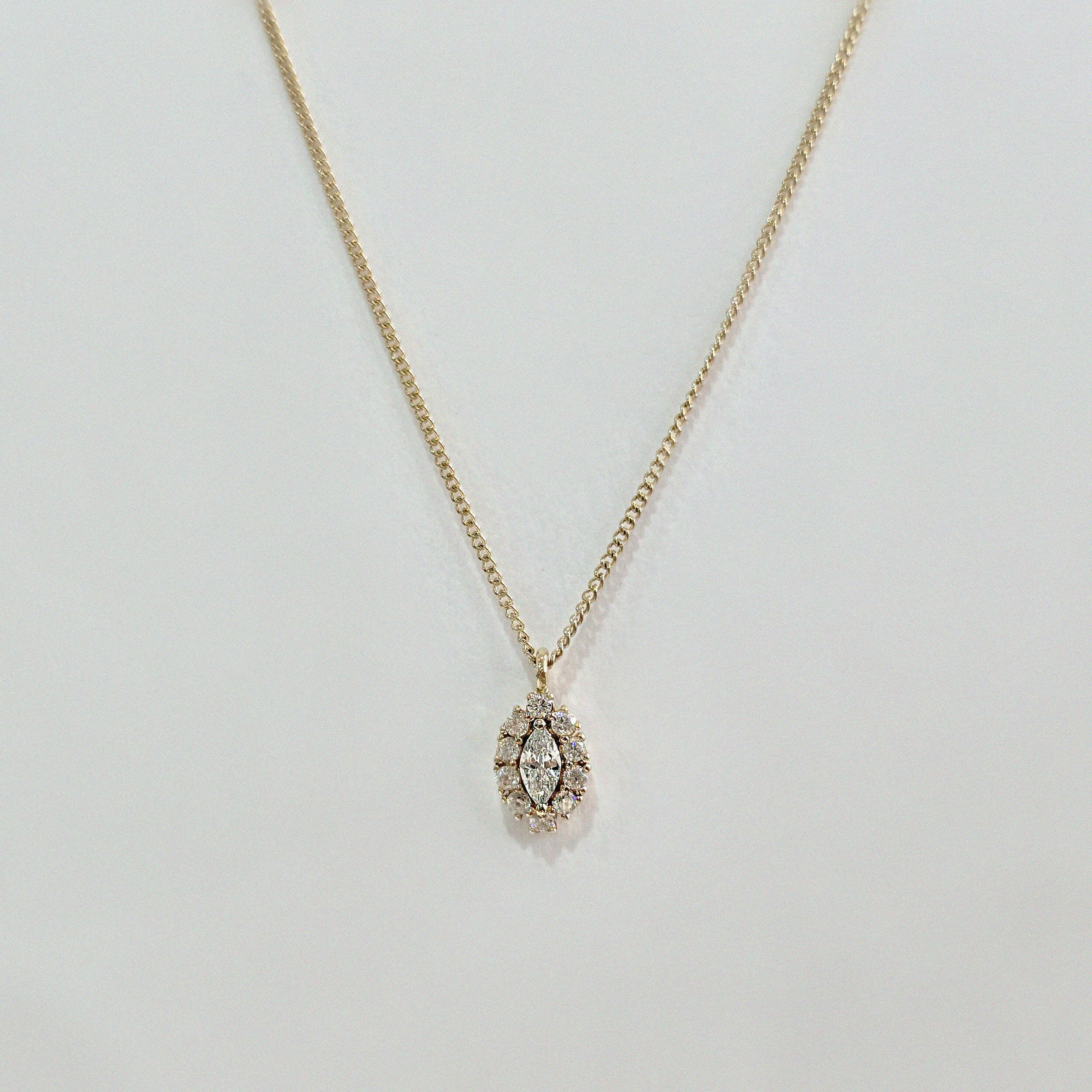 Close-up of 5x7mm marquise-cut cubic zirconia surrounded by micro-crystal halo in high-polish gold setting