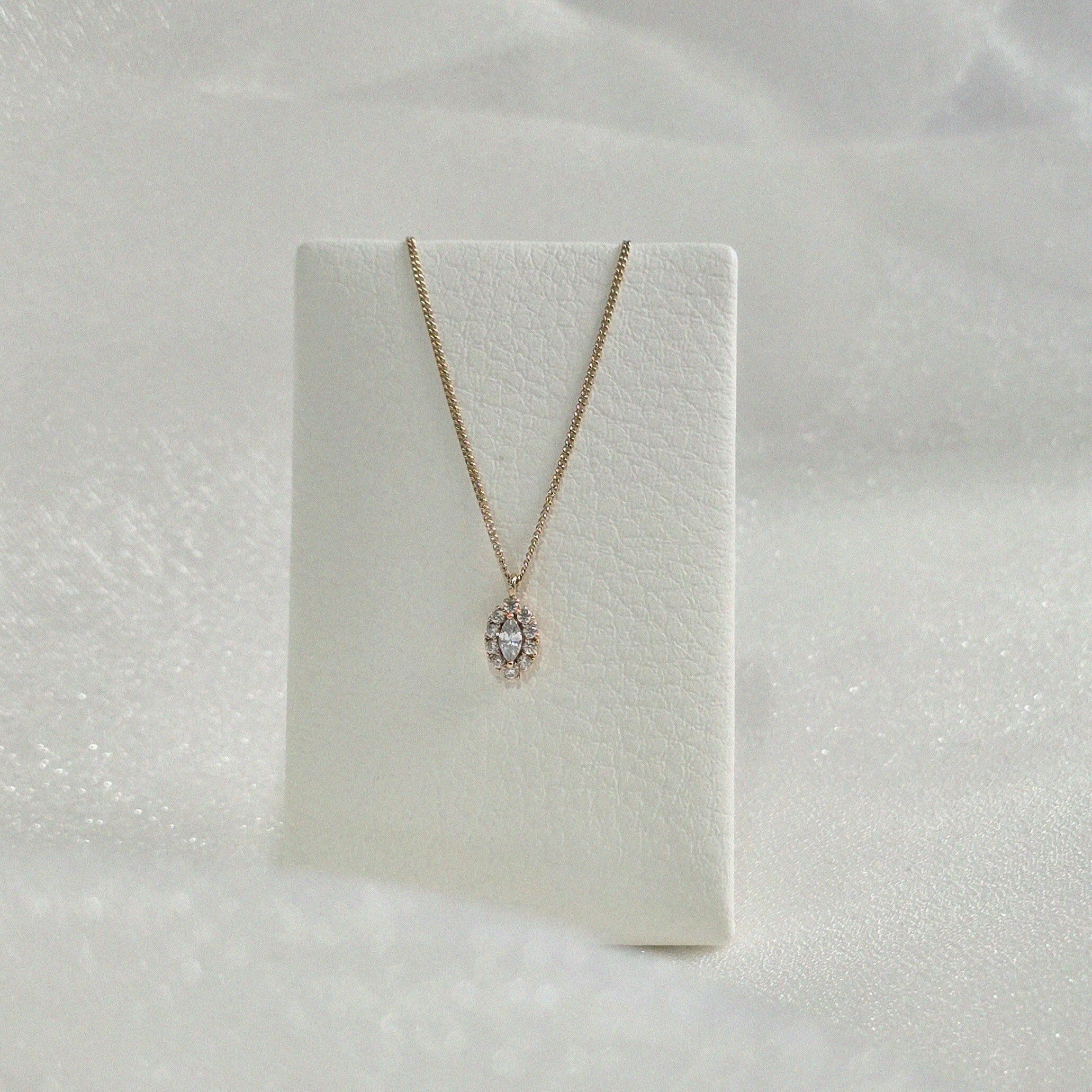 Gleam Crystal Necklace draped over a necklace stand for display