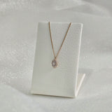 14K Solid Gold Gleam Necklace styled on a minimal necklace stand with soft lighting