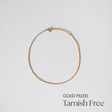 Minimalist gold-filled Ally Chain Anklet laid flat on white background, showcasing dainty design