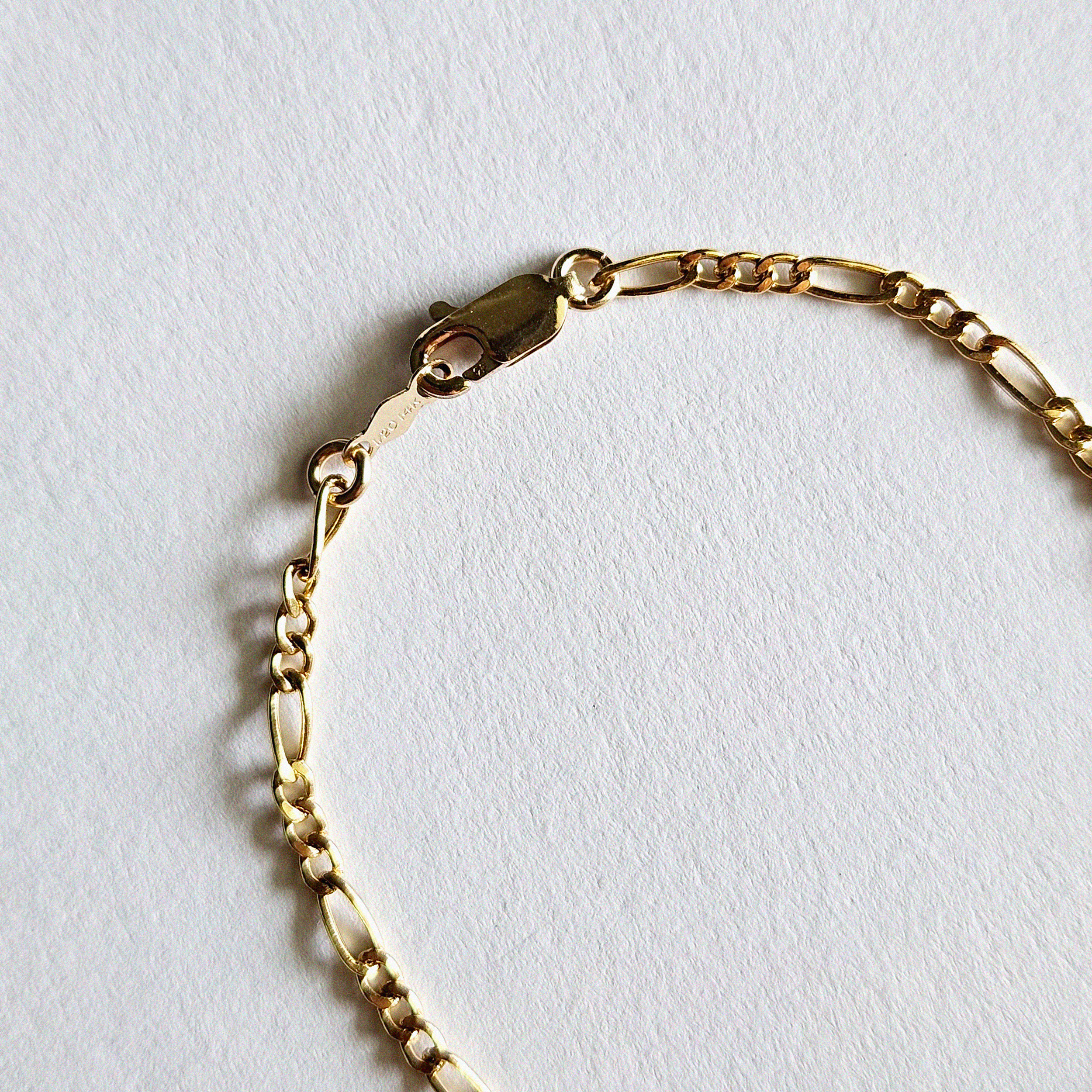 Zoomed-in view of lobster clasp and end links on Figaro bracelet
