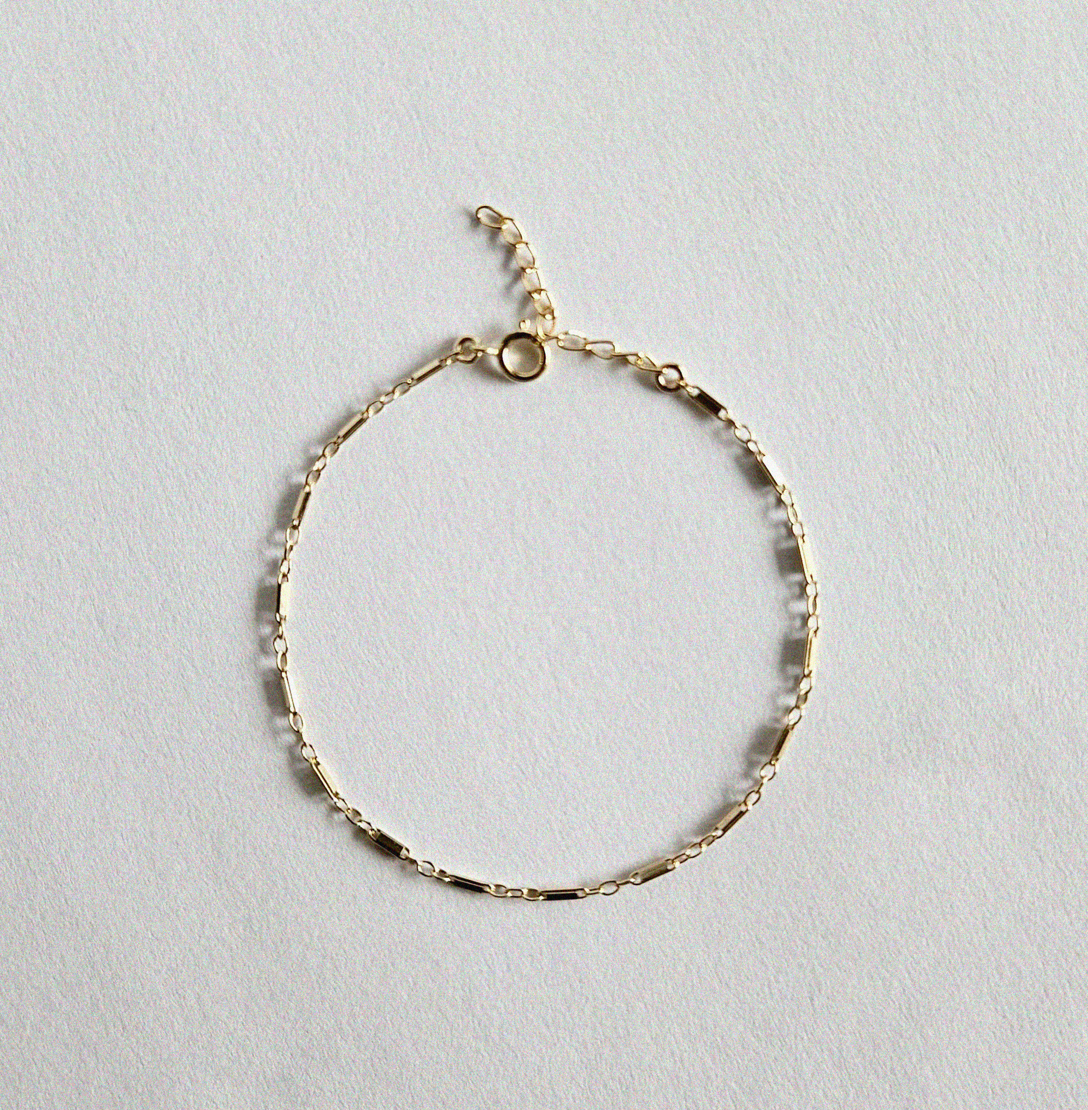 Flat lay of Bonbon Bracelet showcasing unique gold chain texture