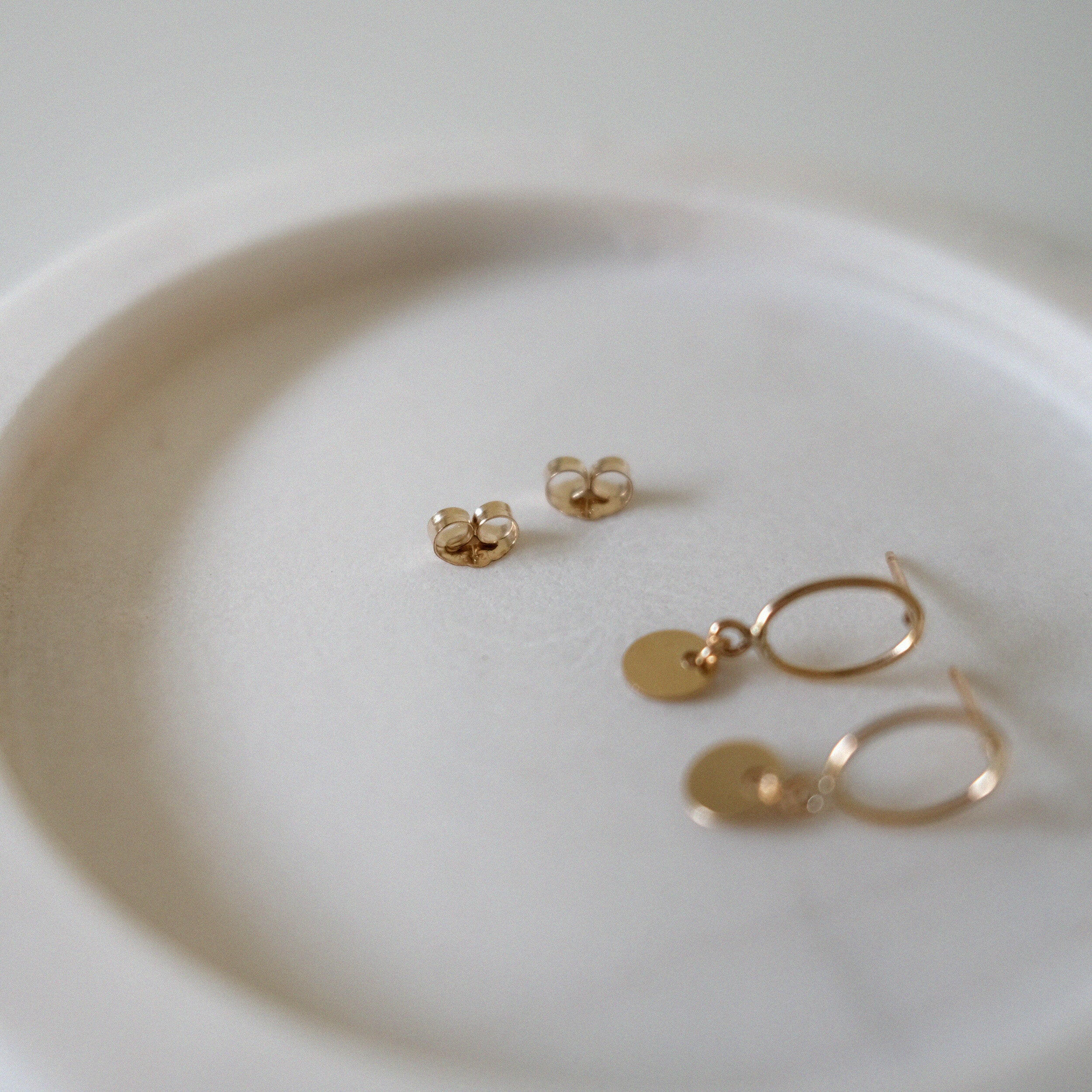 Close-up showing butterfly backs of Celina Disc Earrings.