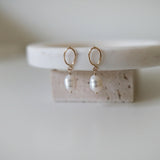 Minimalist front view of pearl drop earrings with natural finish