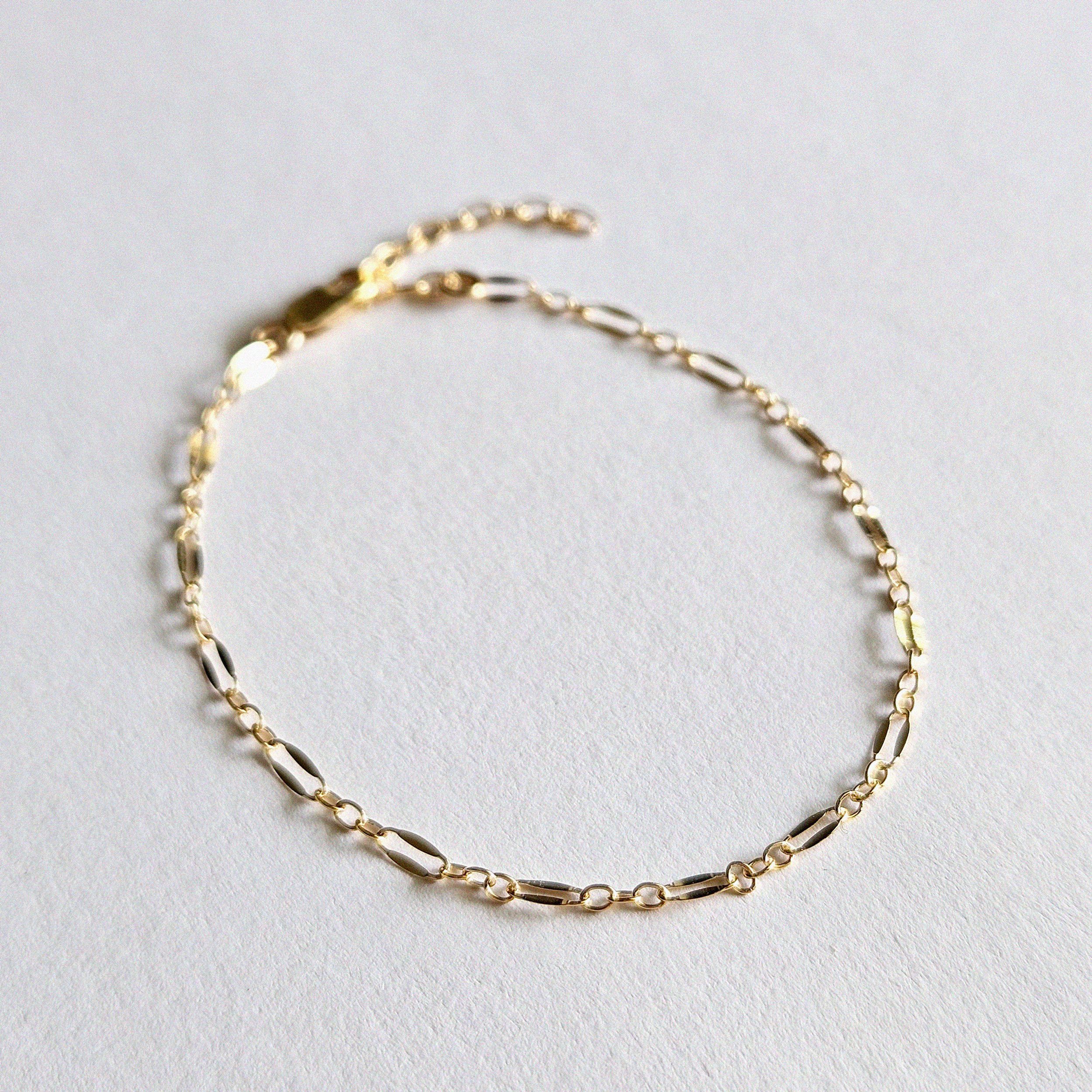 Unique gold filled bracelet with reflective link pattern arranged in curve