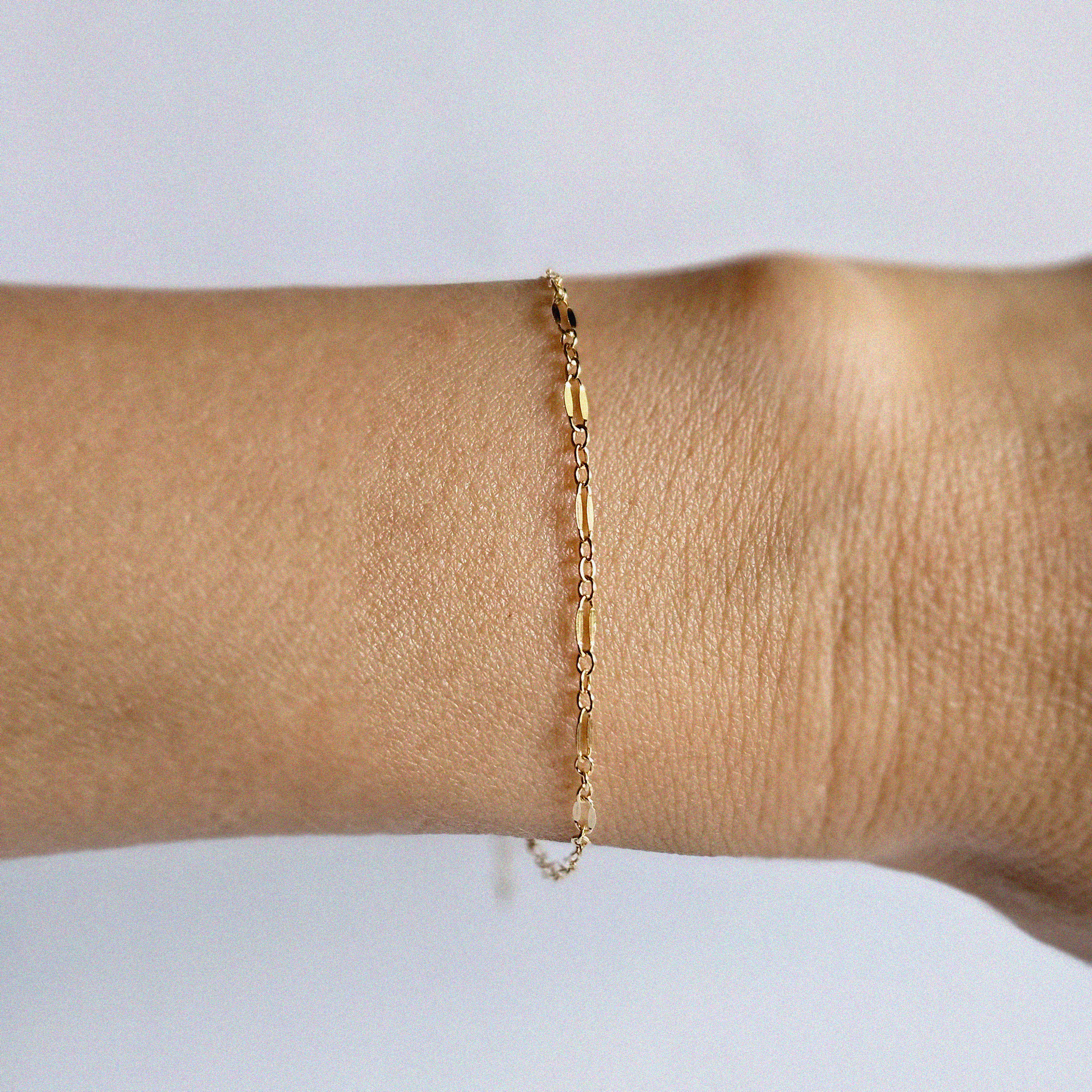 Top-down wrist shot highlighting unique link shape and gold finish