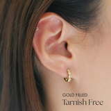 Model wearing Crystal Stone Huggies in clear colour solo in earlobe, sparkling cubic zirconia in focus