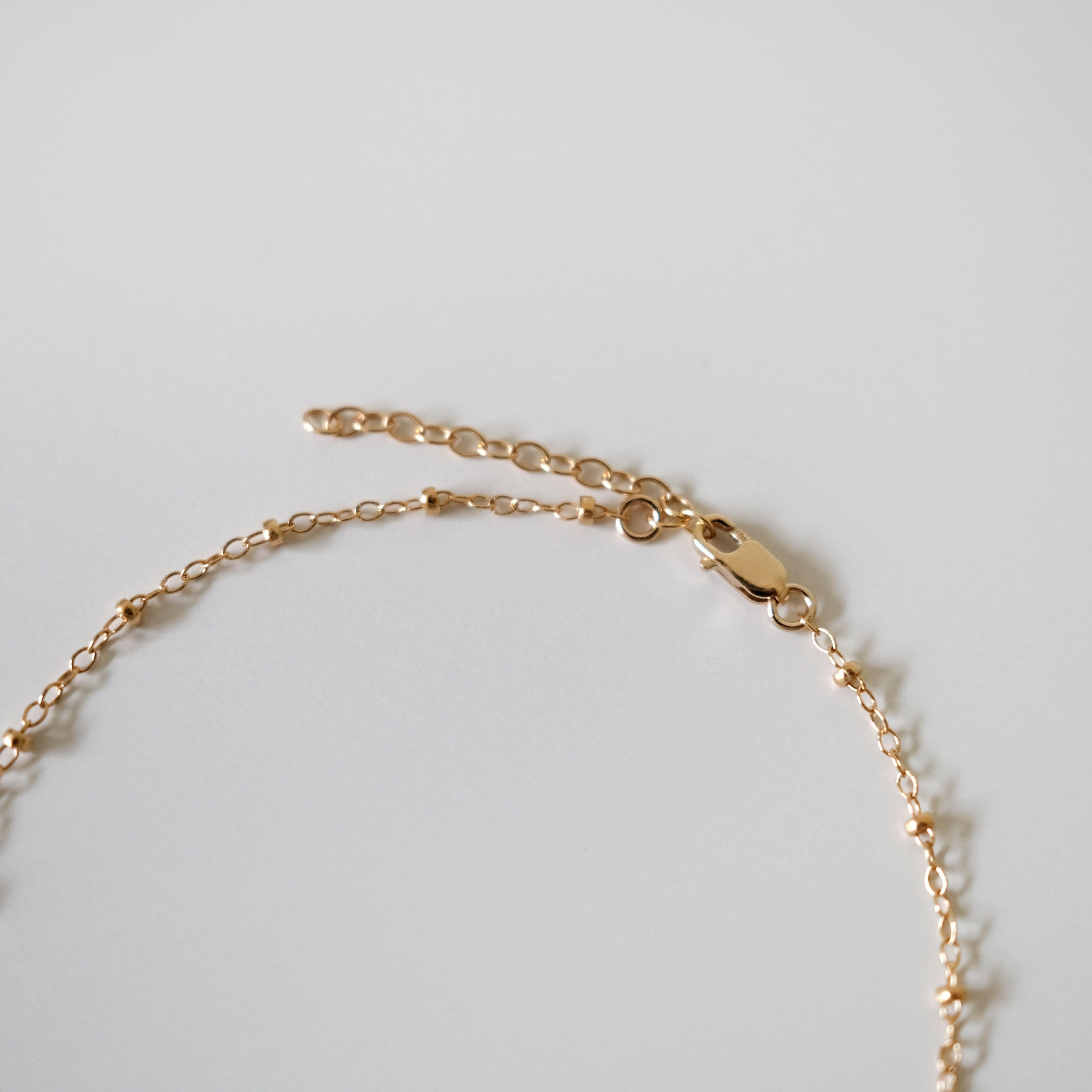 Close-up of gold-filled lobster clasp and extension chain on Dotty Anklet showing polished finish