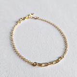 Flat lay of minimal gold bracelet with detailed central chain