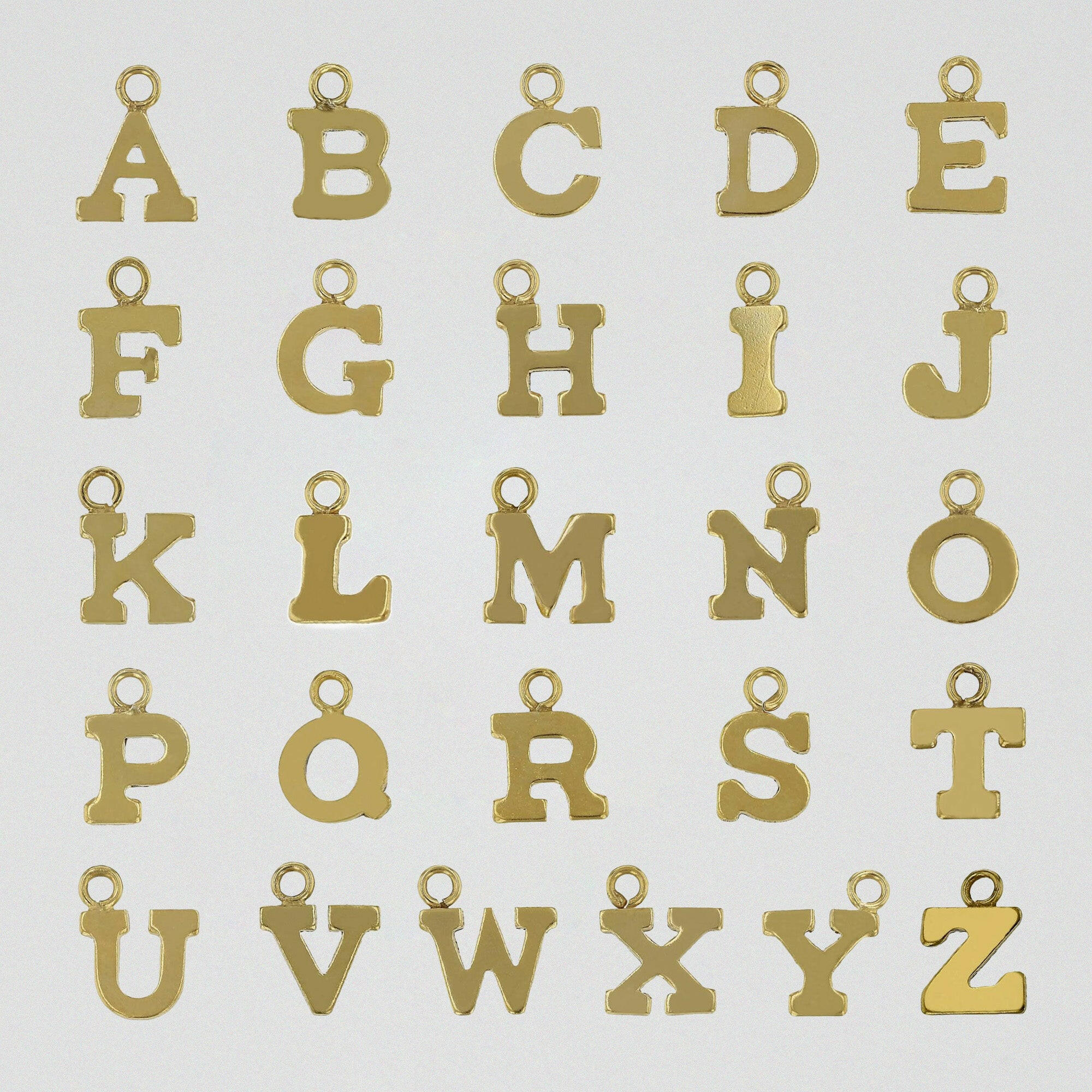 A to Z gold-filled initial charms displayed flat on a white surface.