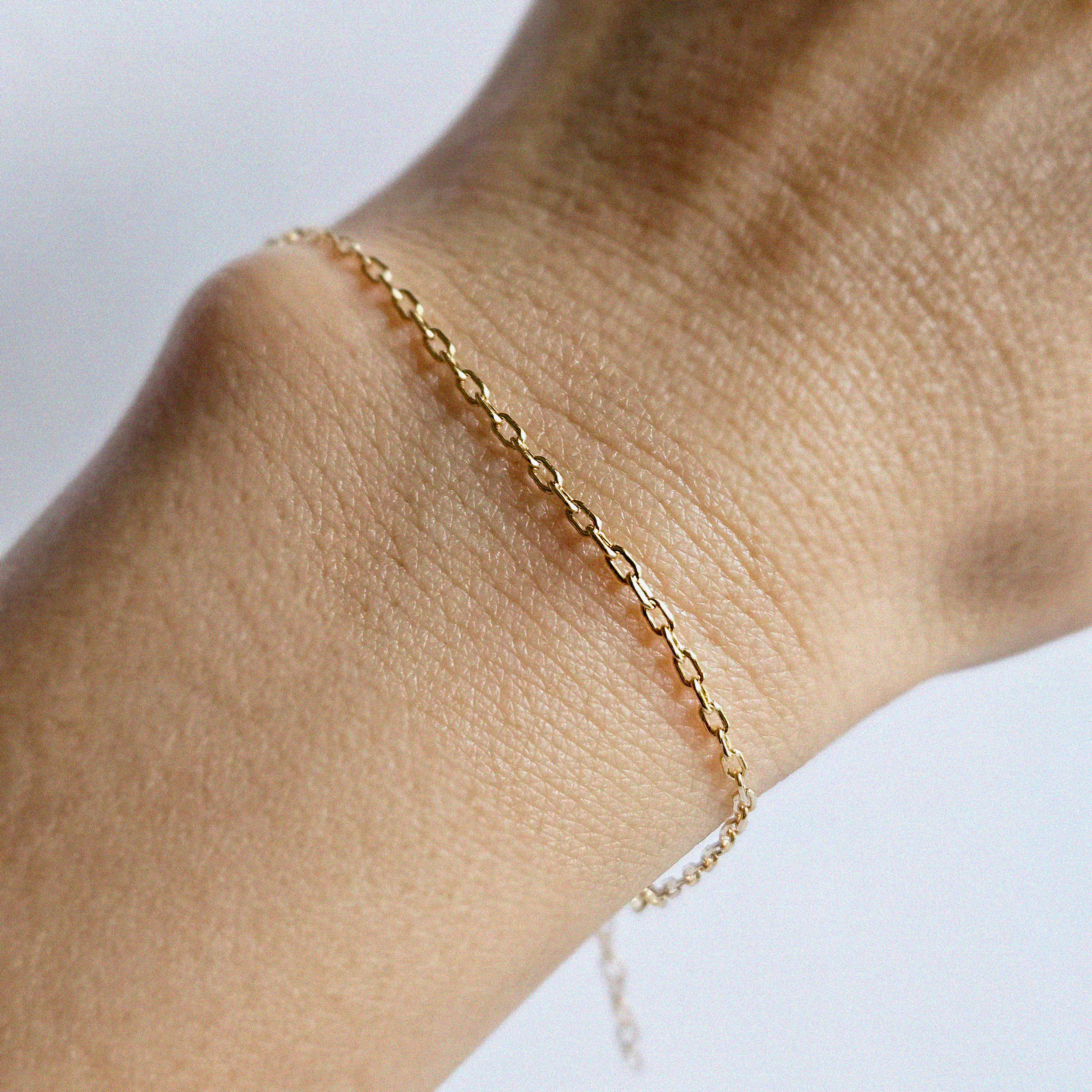 Model’s wrist wearing Kos Chain Bracelet alone in minimalist styling