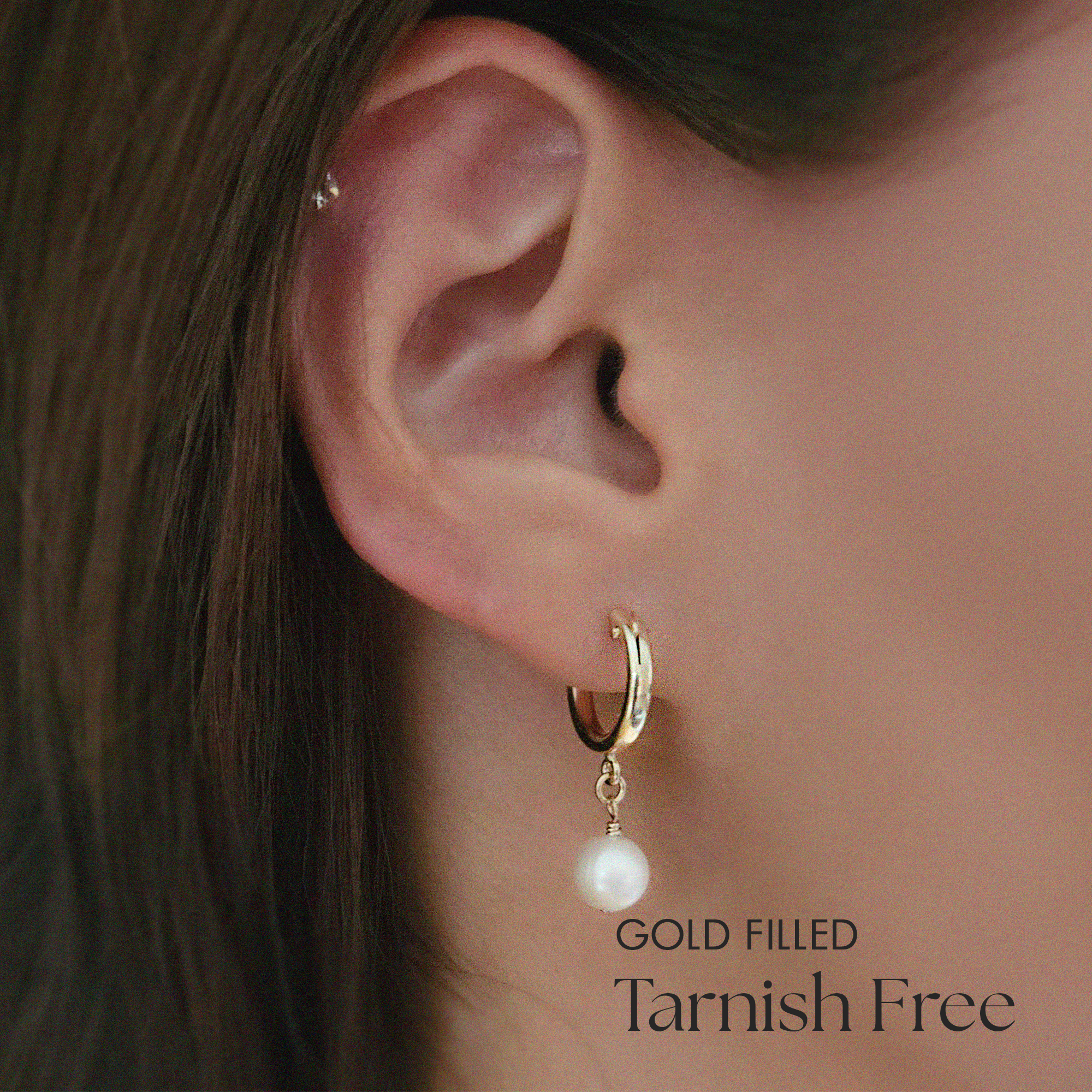 Model wearing Perla Flex Hoops, highlighting the elegant drop of the freshwater pearl