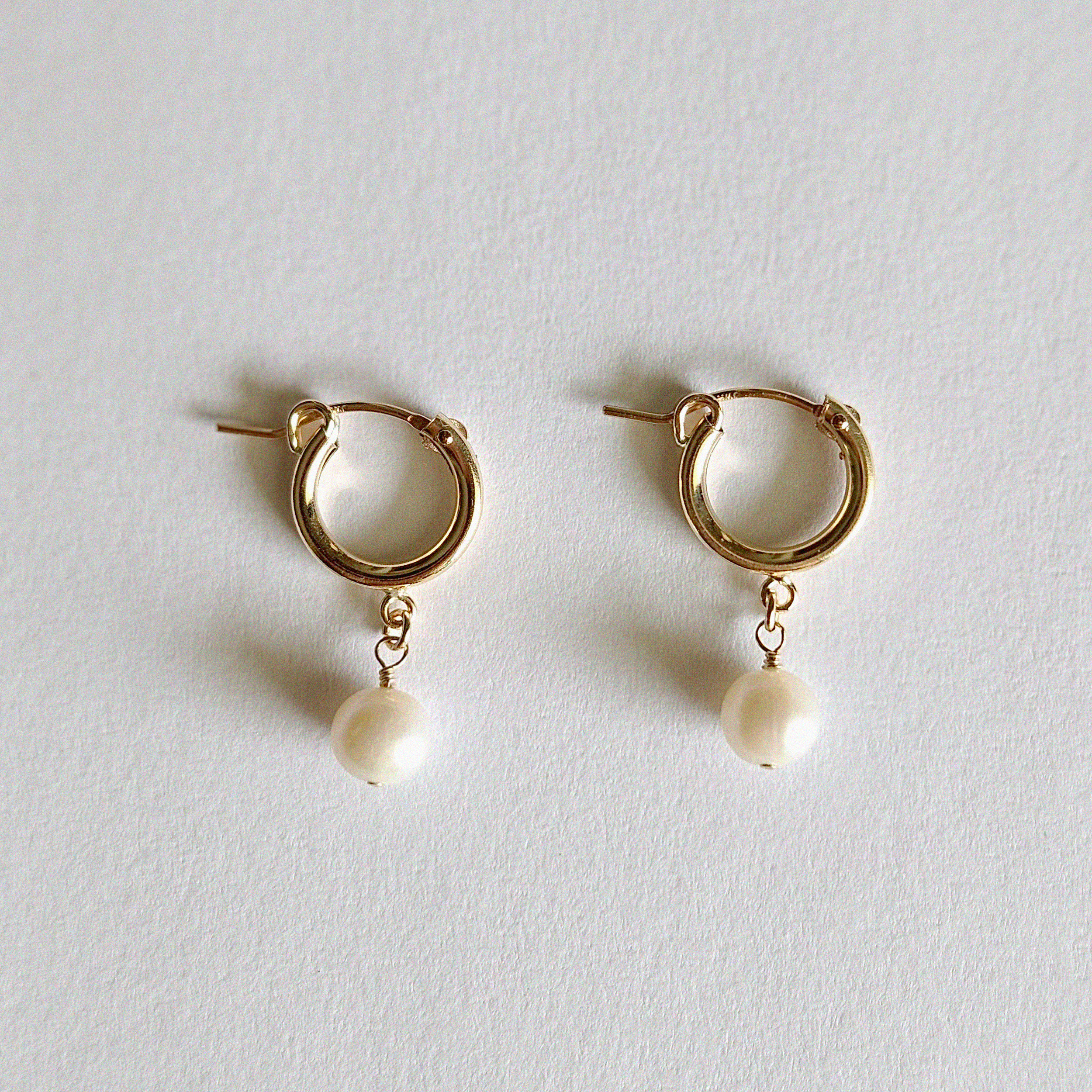 Top-down image of Perla Flex Hoops arranged on a soft-toned jewelry tray