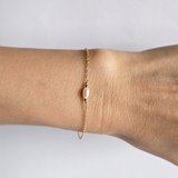 Syros Bracelet worn on wrist from above, pearl centered in gold chain