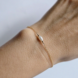 Elegant gold and pearl bracelet styled solo on wrist
