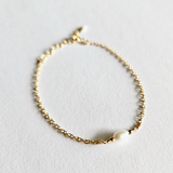 Flat lay of gold chain bracelet with large freshwater pearl detail