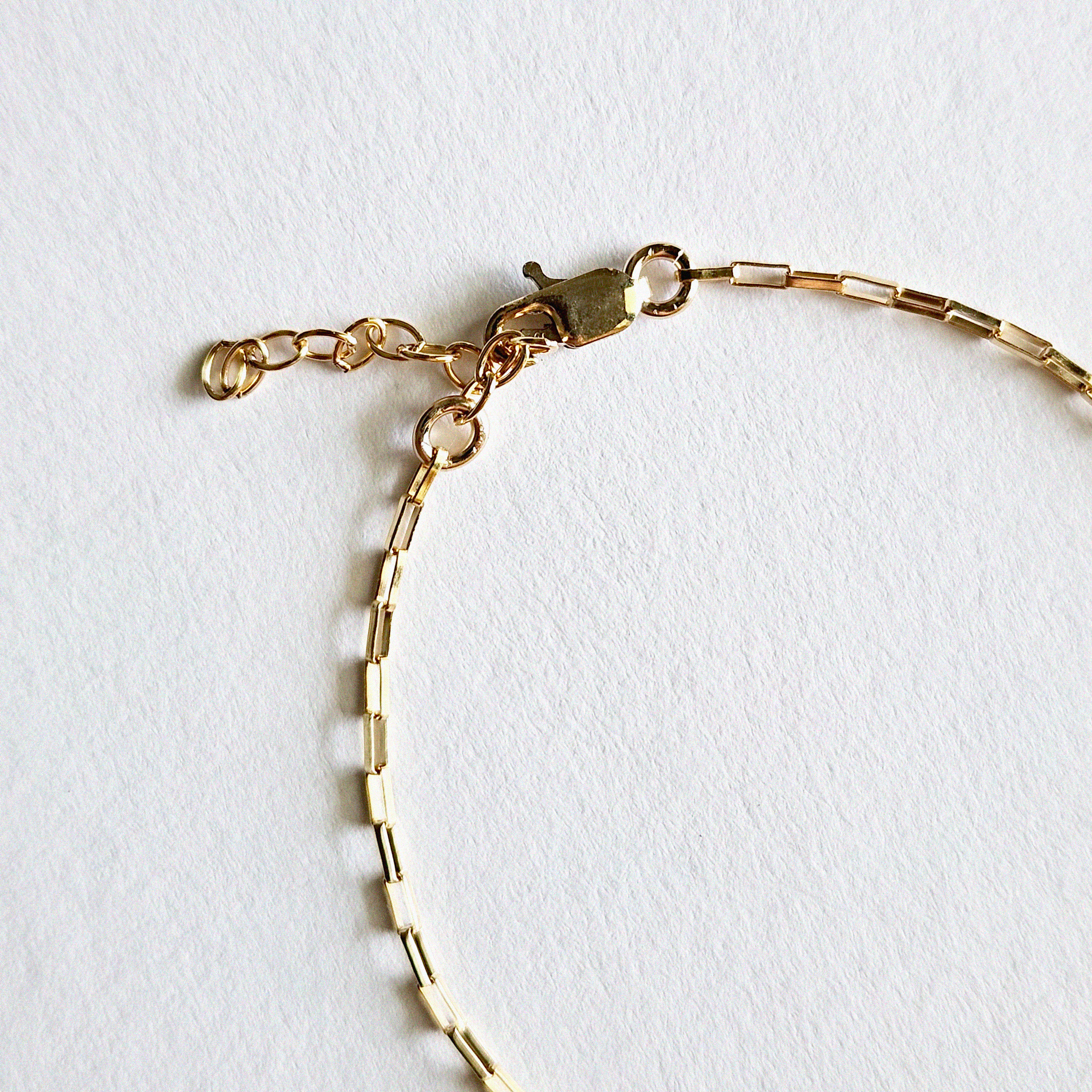 Detailed image of lobster clasp and extension links for adjustable fit