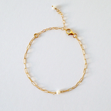 Bracelet displayed in gentle curve with chain links and central pearl