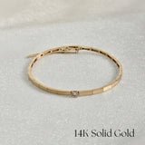 14K Grazia Diamond Bracelet with single center diamond displayed on shimmery fabric background
