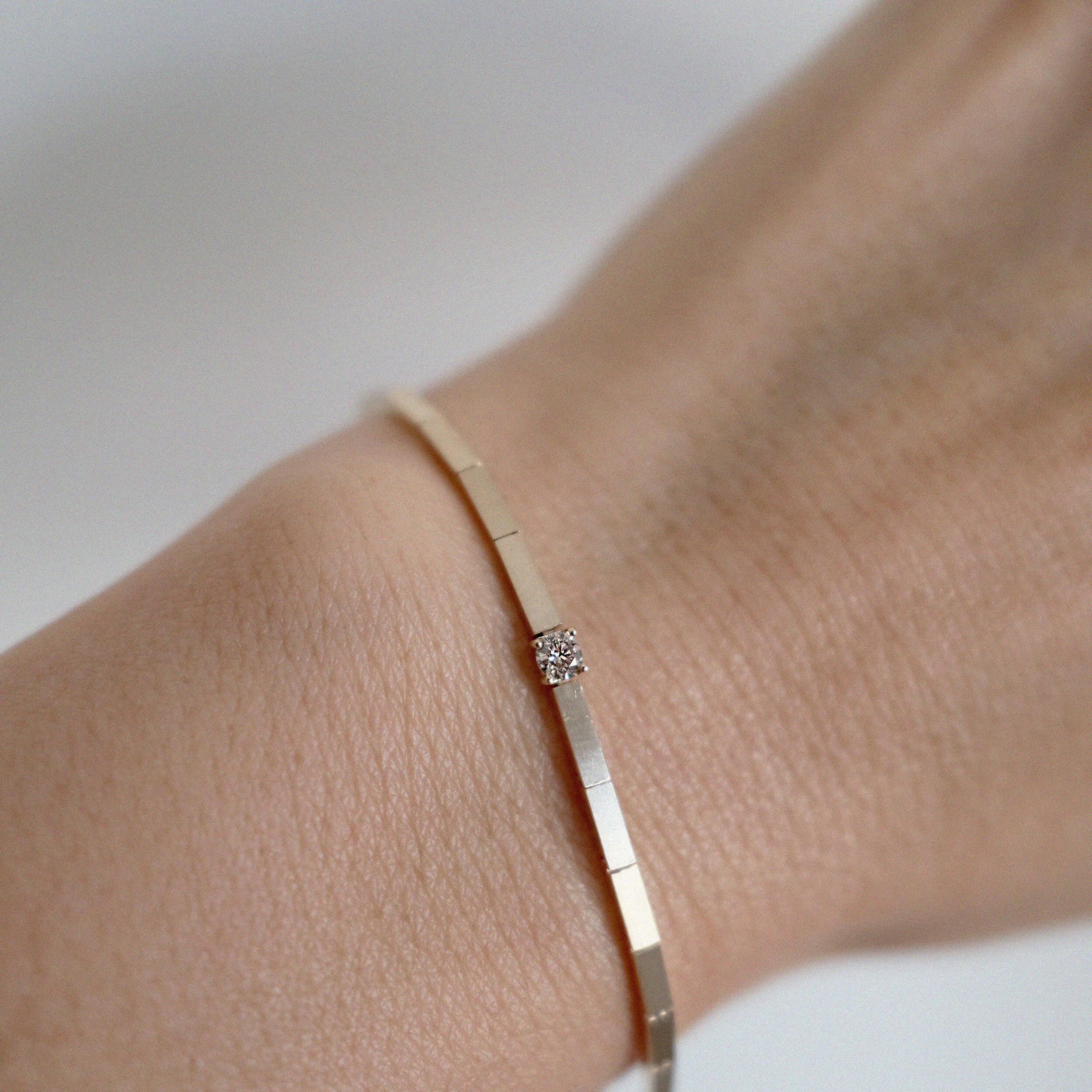 Close-up of the Grazia Bracelet showcasing a single diamond set in a fine 14K gold chain