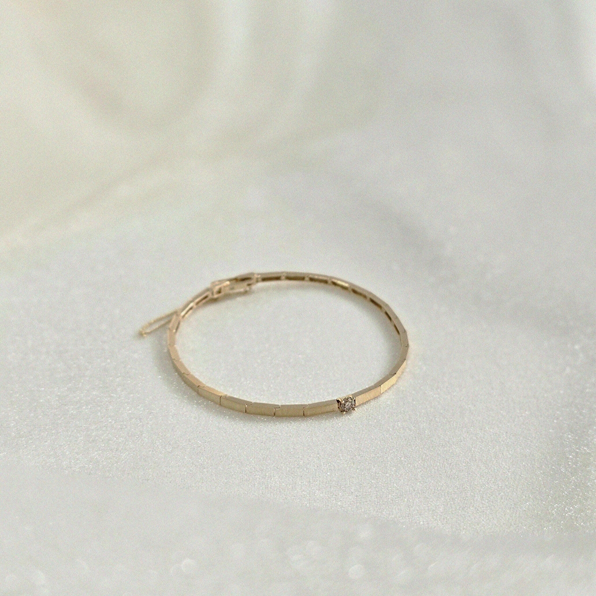 Minimalist gold bracelet with 3mm diamond styled flat with soft lighting