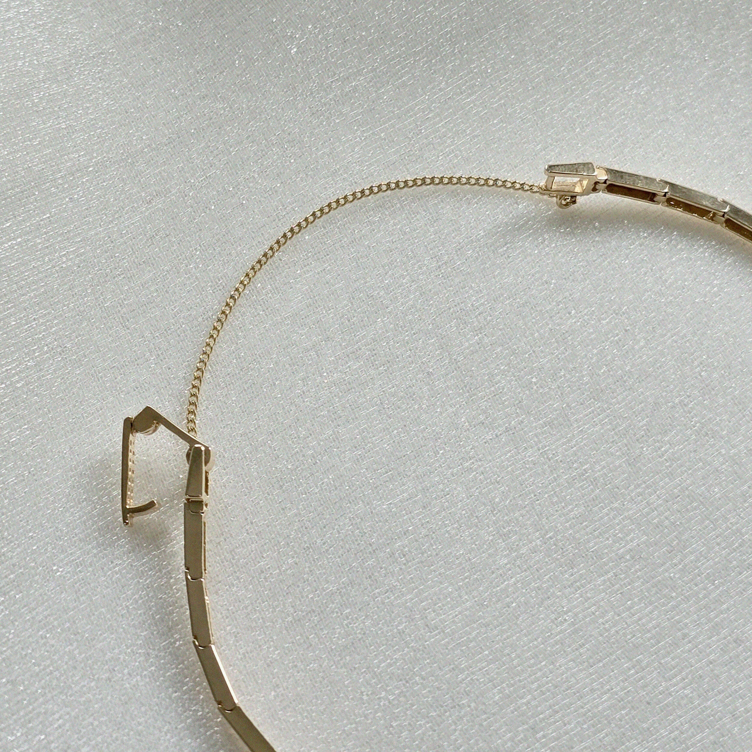 Detailed view of secure box clasp and gold safety chain on solid gold bracelet
