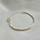 Side shot of the 14K Grazia Diamond Bracelet’s clasp and safety chain on textured fabric