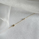 Custom initial gold bracelet with diamond accent displayed flat in soft light