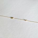 Close-up of the 2.5mm diamond and letter H charm on fine gold chain bracelet