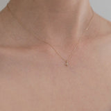 Elegant styling of the diamond cross pendant against bare neckline