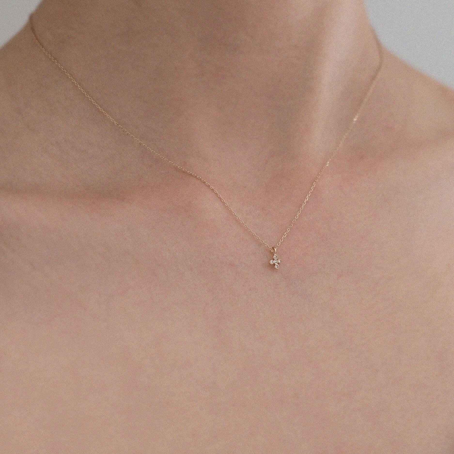 Elegant styling of the diamond cross pendant against bare neckline