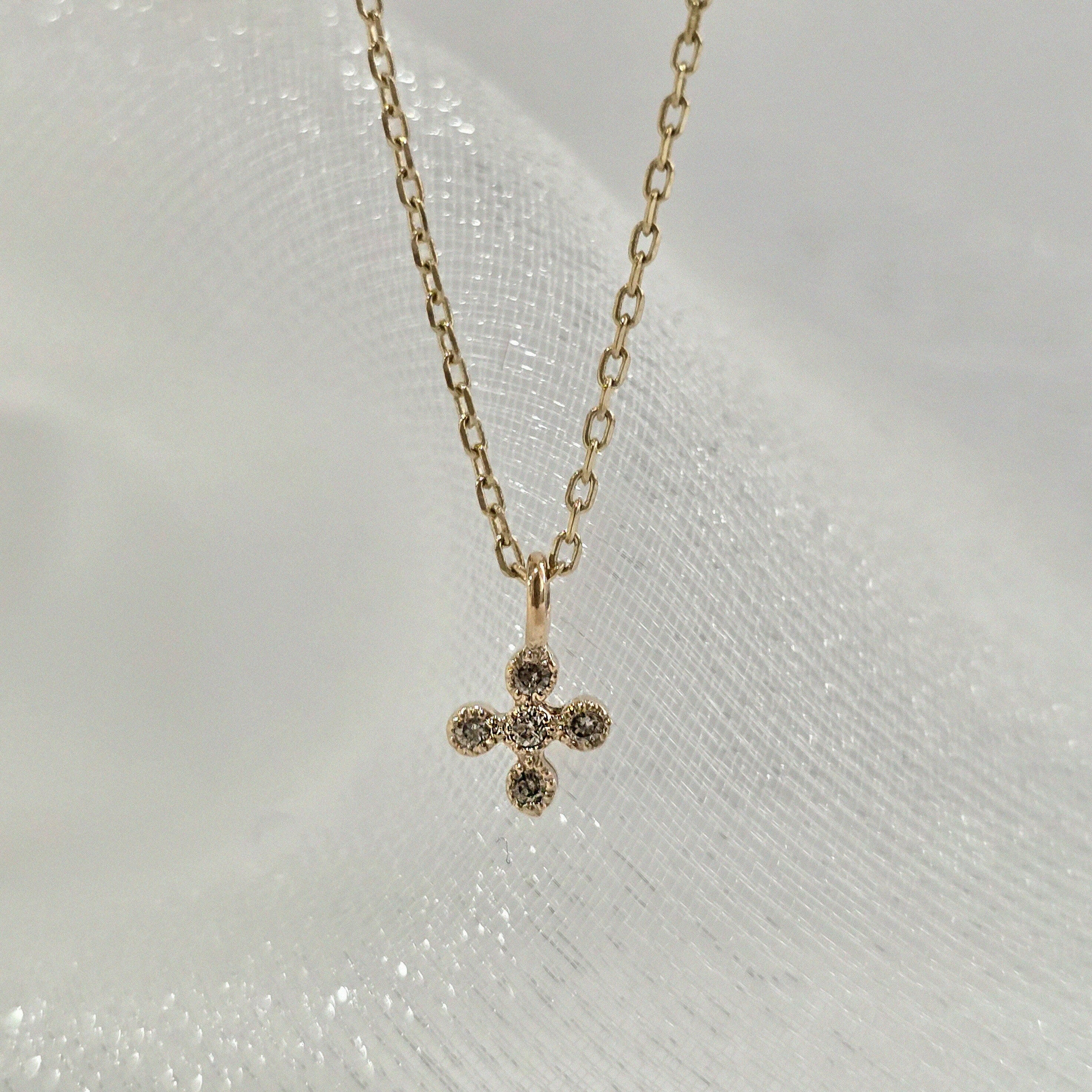 Macro shot of the La Cross Diamond Necklace highlighting the pavé-set diamonds.