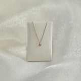 La Cross Diamond Necklace displayed on a soft white leather necklace holder, highlighting its graceful drape