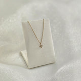 Diamond cross pendant showcased upright on a jewelry stand