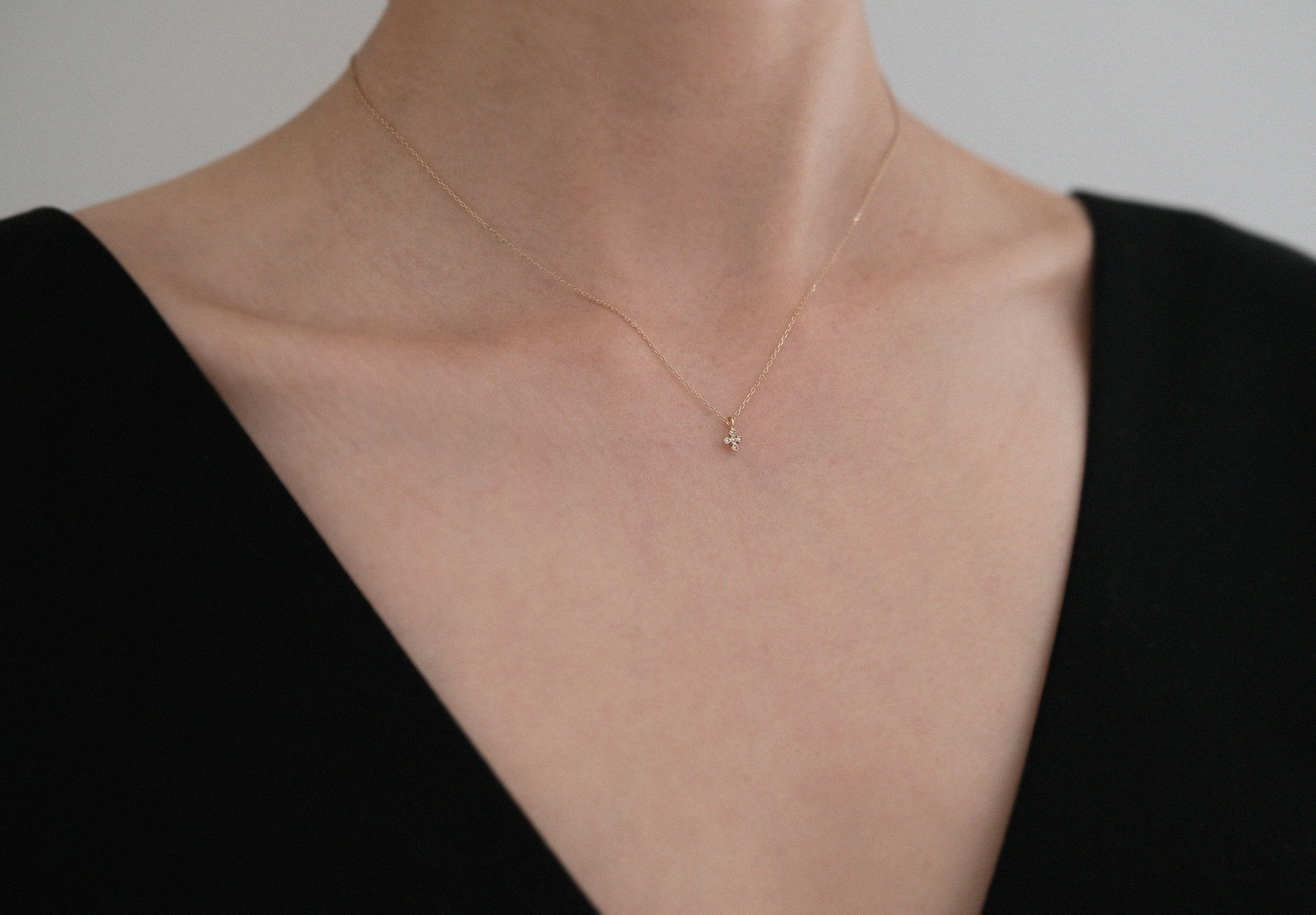 Model wearing the La Cross Diamond Necklace with a black off-shoulder top, showcasing its refined elegance